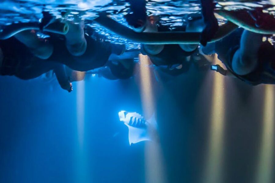 Big Island: Night Swim with Manta Ray with Hot Chocolate - Holding the lighted raft in the dark